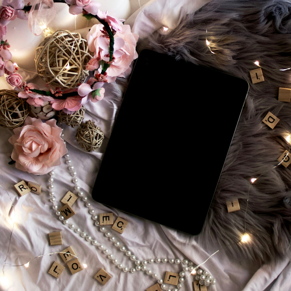 black tablet computer on white and gold floral textile