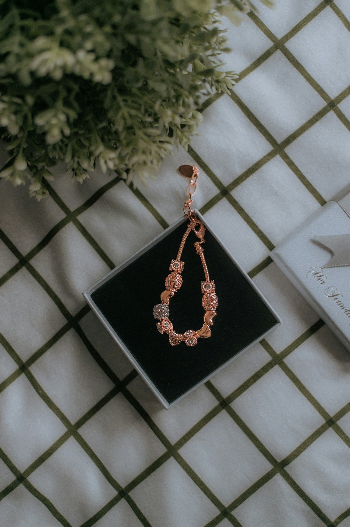 gold and black beaded necklace on black box
