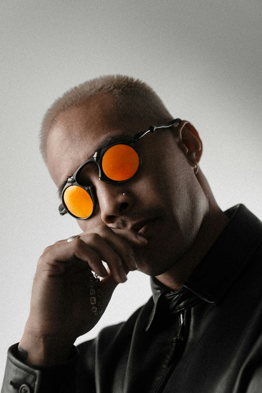 Man with orange tinted sunglasses and short hair.