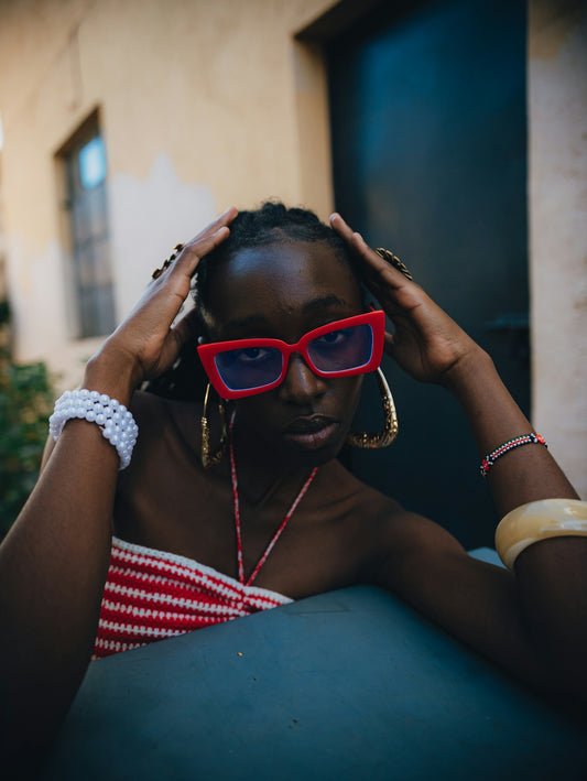 A woman with red glasses and jewelry