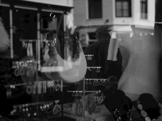 Reflection of a person in a jewelry store window.